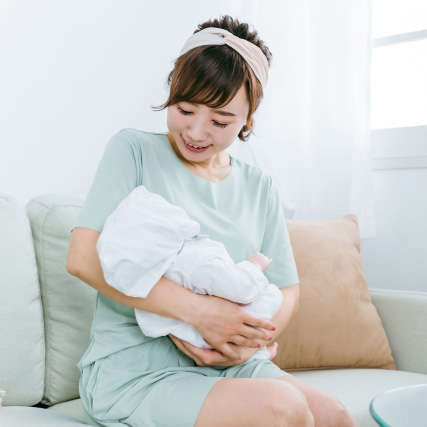 赤ちゃんをあやす産後の女性イメージ画像